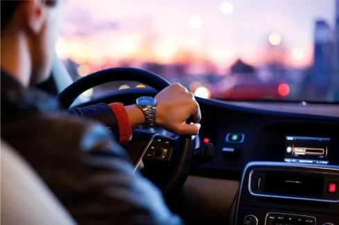 Een man die een auto bestuurt