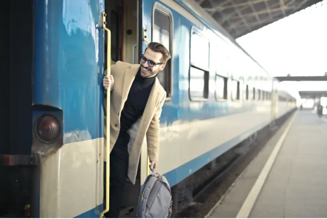 Een man rijdt met de trein naar het vliegveld