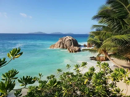 Granieten rotsblokken en turquoise water op een strand op de Seychellen.